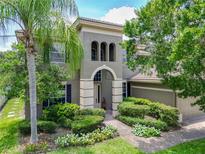Charming two-story home featuring manicured landscaping and an inviting arched entryway at 3213 Kentshire Blvd, Ocoee, FL 34761