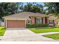 Charming single-story home with a well-manicured lawn, two-car garage and mature trees in a suburban setting at 356 Via Tuscany Loop, Lake Mary, FL 32746