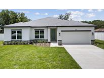 Charming single-story home with well-manicured lawn and attached two car garage on a sunny day at 3944 Sw 130Th Loop, Ocala, FL 34473