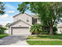 Charming two-story home featuring a well-maintained lawn, mature trees, and a two-car garage at 4208 Lugano Ct, Kissimmee, FL 34746