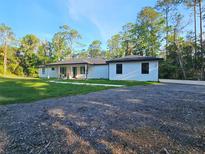 Charming single-story home featuring a modern design with well-maintained lawn and ample parking space at 4825 N Fort Christmas Rd, Christmas, FL 32709