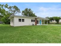 Charming single-story home with a well-maintained lawn and a covered front porch with a bright blue door at 5115 W Livingston St, Orlando, FL 32811