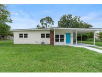 Charming single-story home with a well-manicured lawn and a bright blue front door at 5115 W Livingston St, Orlando, FL 32811