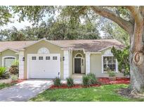 Charming single-story home featuring an attached garage, lush landscaping, and a welcoming entrance at 644 Villa Ct, Clermont, FL 34711