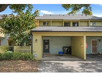 Townhouse exterior with a carport, fenced yard, and mature trees at 7466 Canford Ct # 25, Winter Park, FL 32792