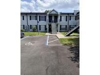 Condo building exterior with a convenient parking area, including accessible parking, and black shutters adding a charming detail at 7632 Forest City Rd # 062A/K/A F, Orlando, FL 32810
