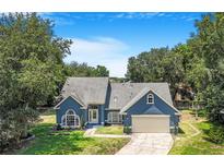 Charming blue home with a well-manicured lawn and inviting curb appeal in a beautiful setting at 7838 Rollingridge Ct, Orlando, FL 32835