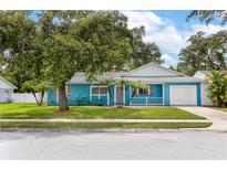 Charming blue single Gathering home with a well manicured front lawn and mature trees at 9014 Great Sound Dr, Orlando, FL 32827