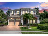 Stunning two-story home featuring a well-manicured lawn, three-car garage, and charming architectural details at 12530 Climbing Vine Ct, Windermere, FL 34786