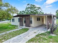 Cozy single-story home featuring a carport and a driveway surrounded by green lawn and mature trees at 1330 Lakeview Rd, Lake Wales, FL 33853