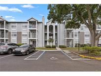 Exterior view of a three story condo with a parking lot, black iron balconies, and well-maintained landscaping at 2550 N Alafaya Trl # 2304, Orlando, FL 32826