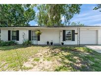 Charming single-story home featuring a white exterior, black shutters, and well-maintained landscaping at 2710 W County Road 44, Eustis, FL 32726