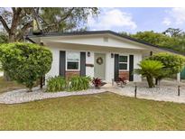 Charming home featuring a lovely light green front door, classic shutters, and beautifully landscaped yard at 280 E Bay Ave, Longwood, FL 32750