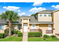 Charming townhome featuring manicured landscaping, a decorative fence, and a welcoming entryway at 3249 Sandy Shore Ln, Kissimmee, FL 34743