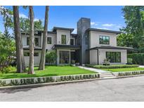 Modern home with gray stucco, black trim, and manicured landscaping for curb appeal at 33 Eastwind Ln, Maitland, FL 32751