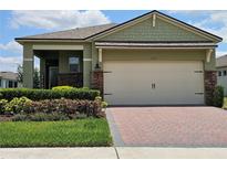 Charming single-Gathering home featuring a two-car garage, brick accents and tidy landscaping at 3371 Yellowtop Loop, Clermont, FL 34714