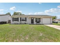 Charming single-story home featuring a well-maintained lawn, a garage, and welcoming curb appeal at 3816 Tram Ct, Orlando, FL 32810