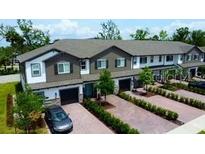 Beautiful townhouse exterior with brick driveways, manicured landscaping and attached garages at 391 Cape Honeysuckle Pl, Sanford, FL 32771