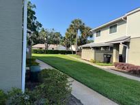 A well-maintained condo exterior with lush green lawn and manicured landscaping on a sunny day at 4596 Pheasant Run Dr # C, Orlando, FL 32808