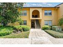 Inviting two-story condo featuring well-maintained landscaping and a charming arched entryway at 758 E Michigan St # 203, Orlando, FL 32806
