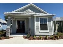 Charming single-story home showcasing stone accents, gray siding, and manicured landscaping at 931 Azalea Walk Cir, Deland, FL 32724