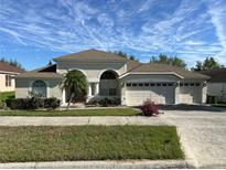 Charming single-story home with a three-car garage and well-manicured landscaping at 10955 Lemay Dr, Clermont, FL 34711