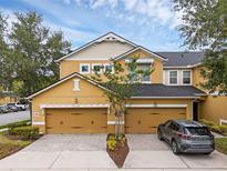 Charming townhouse with two-car garage and beautifully landscaped front yard under a blue sky at 14025 Oasis Springs Ln # 901, Windermere, FL 34786