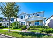 Charming two-story home featuring mature landscaping and a well-maintained lawn on a sunny day at 14753 Snowy Egret St, Winter Garden, FL 34787