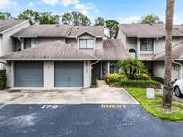 Inviting townhouse featuring attached garage, mature landscaping, and guest parking at 179 Crown Point Cir, Longwood, FL 32779