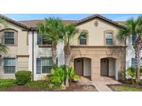 Inviting townhouse featuring a red tile roof, front landscaping, and charming entryway at 1943 Majorca Dr, Kissimmee, FL 34747