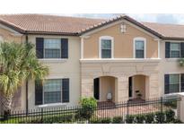 Charming townhome with black shutters, tile roof, and an inviting front entry with covered seating area at 1979 Majorca Dr, Kissimmee, FL 34747