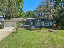 Charming single-story home with a well-manicured lawn, lush landscaping, and a two-car garage at 216 San Fernando Ct, Sanford, FL 32773