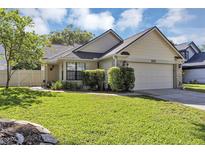 Charming single-story home with a well-manicured lawn and attached two-car garage at 2227 Doulton Dr, Orlando, FL 32812