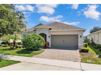 Charming home featuring a well-maintained lawn, a brick driveway, and an attached two-car garage at 2233 Antilles Club Dr, Kissimmee, FL 34747
