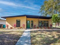 Inviting single-story home with vibrant landscaping and a walkway leading to a charming green front door at 332 N Lakeland Ave, Orlando, FL 32805