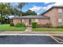 Charming brick home with lush lawn, featuring a palm tree and colorful peach shutters at 416 Banyon Tree Cir # 108, Maitland, FL 32751