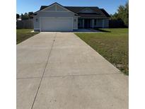 Charming single-story home with a well-manicured lawn and a two-car garage at 468 Marion Oaks Blvd, Ocala, FL 34473