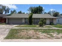 Modest single-story home with a two-car garage and a front yard in need of landscaping at 5918 Stratton Ln, Orlando, FL 32808