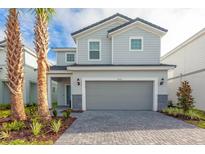 Charming two-story home features a gray color scheme, manicured landscaping and a two car garage at 7352 Oakmoss Loop, Davenport, FL 33837
