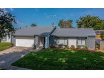 Charming single-Gathering home featuring a grey roof, stone accents, and well-manicured lawn at 838 Haulover Dr, Altamonte Springs, FL 32714