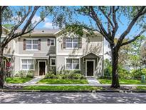 Charming townhome with well-manicured lawn and inviting entrance framed by mature trees on a sunny day at 12335 Cruxbury Dr, Windermere, FL 34786
