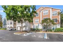 Attractive condo building with attached garages and accessible parking spaces at 12837 Madison Pointe Cir # 206, Orlando, FL 32821