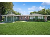 Charming single-story home with brick accents, a well-manicured lawn, and a two-car garage at 1389 Gainesville Ln, Deltona, FL 32725
