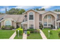 Charming townhome with manicured lawn and inviting facade with unique architectural detail at 1642 Windsor Oak Ct, Kissimmee, FL 34744