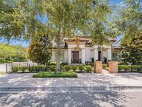 Charming two-story home with lush landscaping, brick accents and mature shade trees at 242 W Lyman Ave, Winter Park, FL 32789