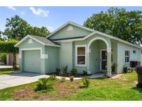 Charming single-story home with light green stucco, attached garage, and landscaping at 2903 Willow Oak Ct, Kissimmee, FL 34744