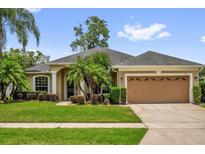 Charming single-story home with a well-manicured lawn, lush landscaping, and an attached two-car garage at 3304 Bennington Ct, Winter Park, FL 32792