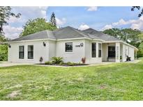 Charming single-story home with stucco exterior, black-framed windows, and well-manicured lawn at 455 Orange Ave, St Cloud, FL 34769