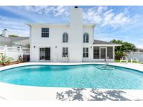 Relaxing backyard featuring a sparkling pool, screened-in patio, and white fencing for serene outdoor living at 554 Queensbridge Dr, Lake Mary, FL 32746