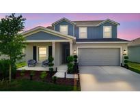 Charming two-story home with a covered front porch and a well-manicured lawn at 700 Trotters Dr, Eagle Lake, FL 33839